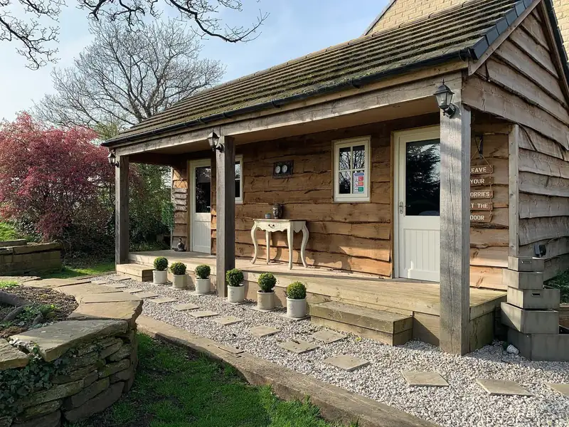 The Le petit spa garden cabin with its porch and stepping stone path
